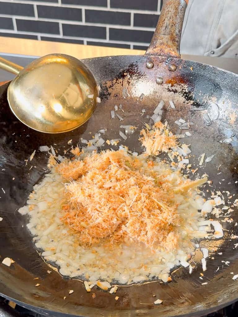 Adding coconut milk to satay sauce