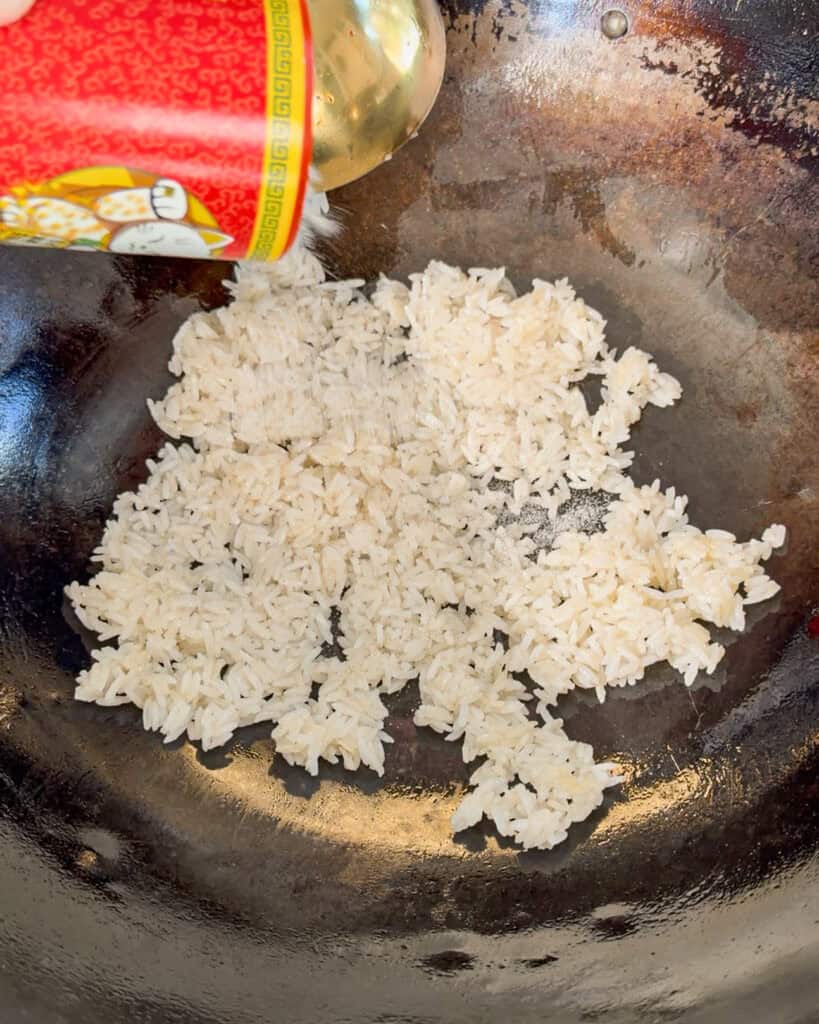 Cooked rice being added to a wok