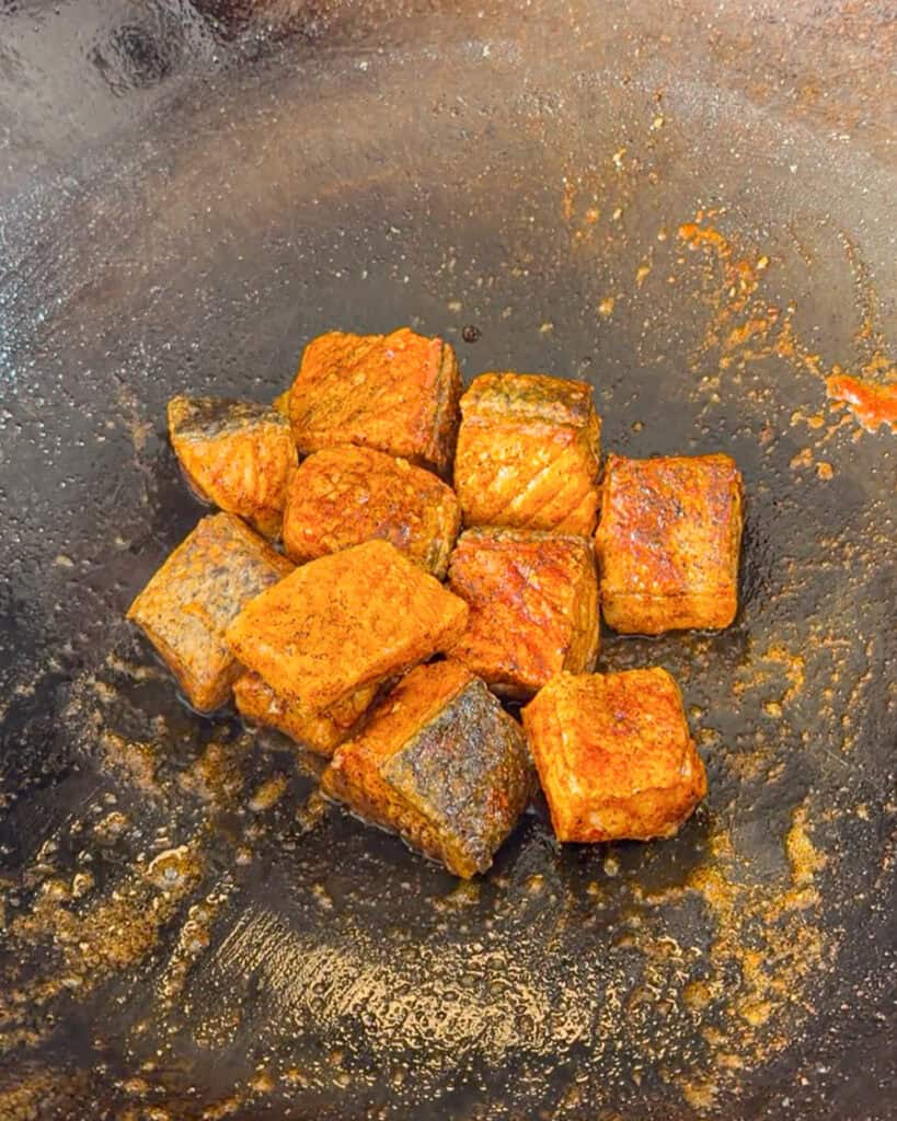 Crispy cooked salmon cubes in wok