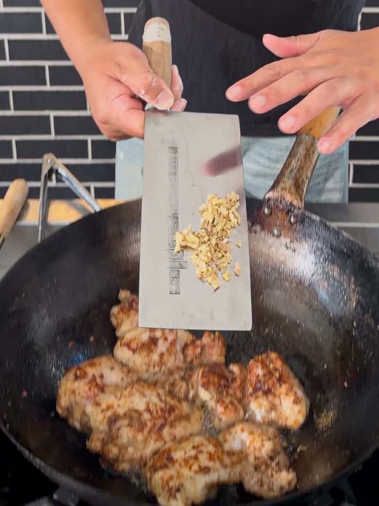 Extra seasoning added to chicken in wok