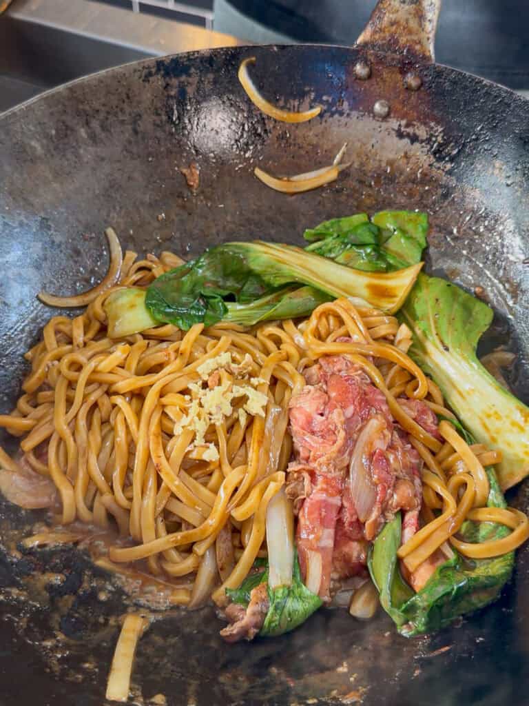 Fresh bok choy added to beef udon stir fry