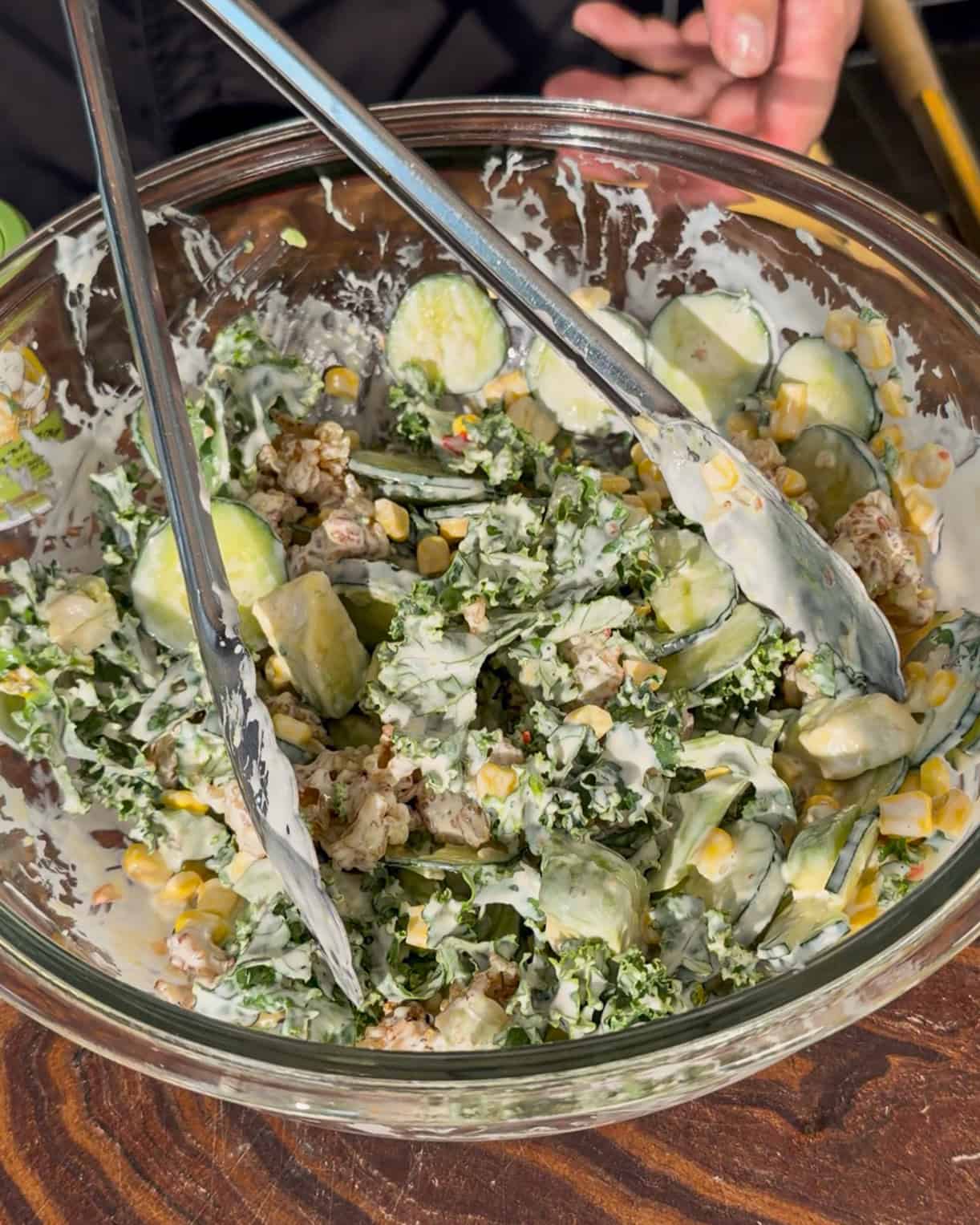 Salad ingredients being mixed with sauce