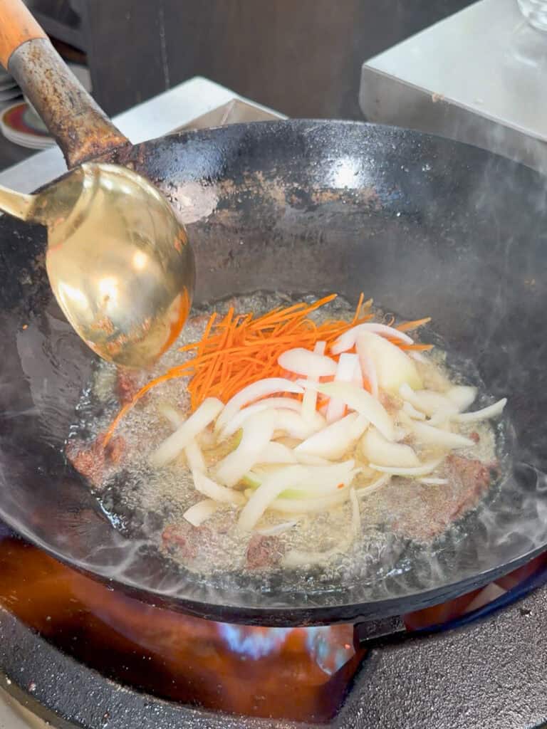 Sauce visibly coating noodles while being heated