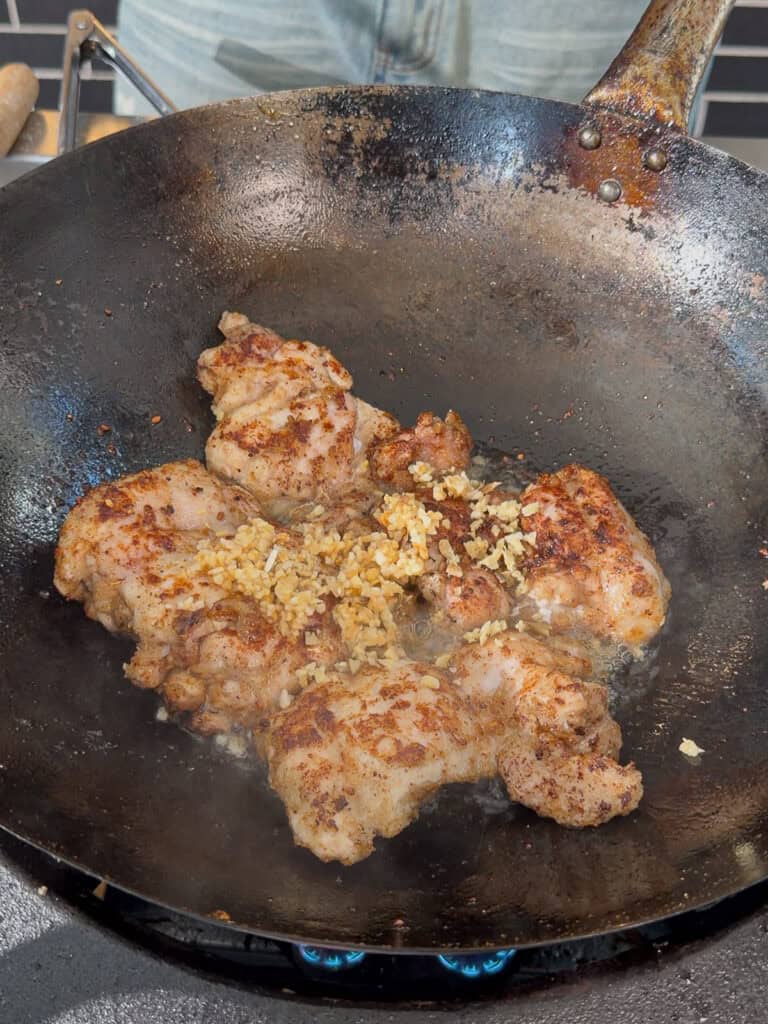 Sauces added to chicken in wok