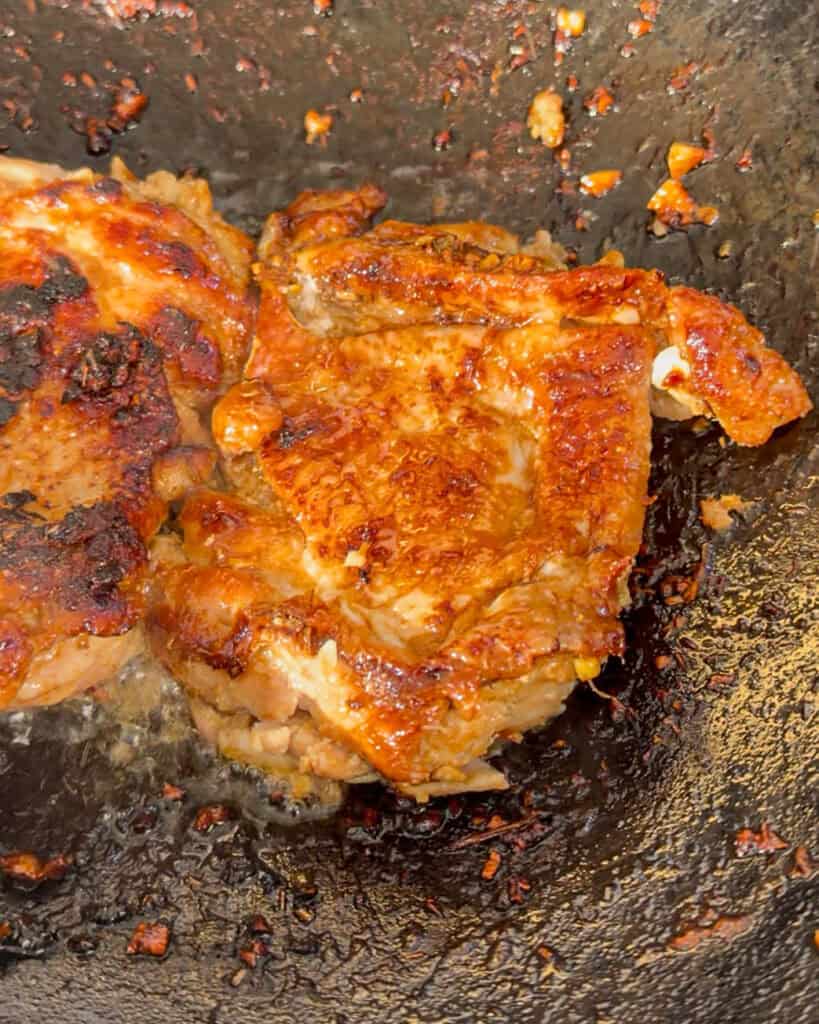 Chicken browning in wok with oil