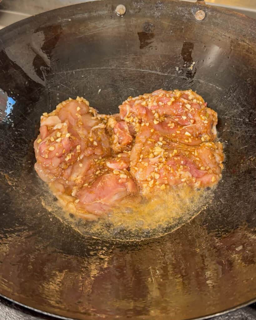 Chicken pieces placed in oiled wok
