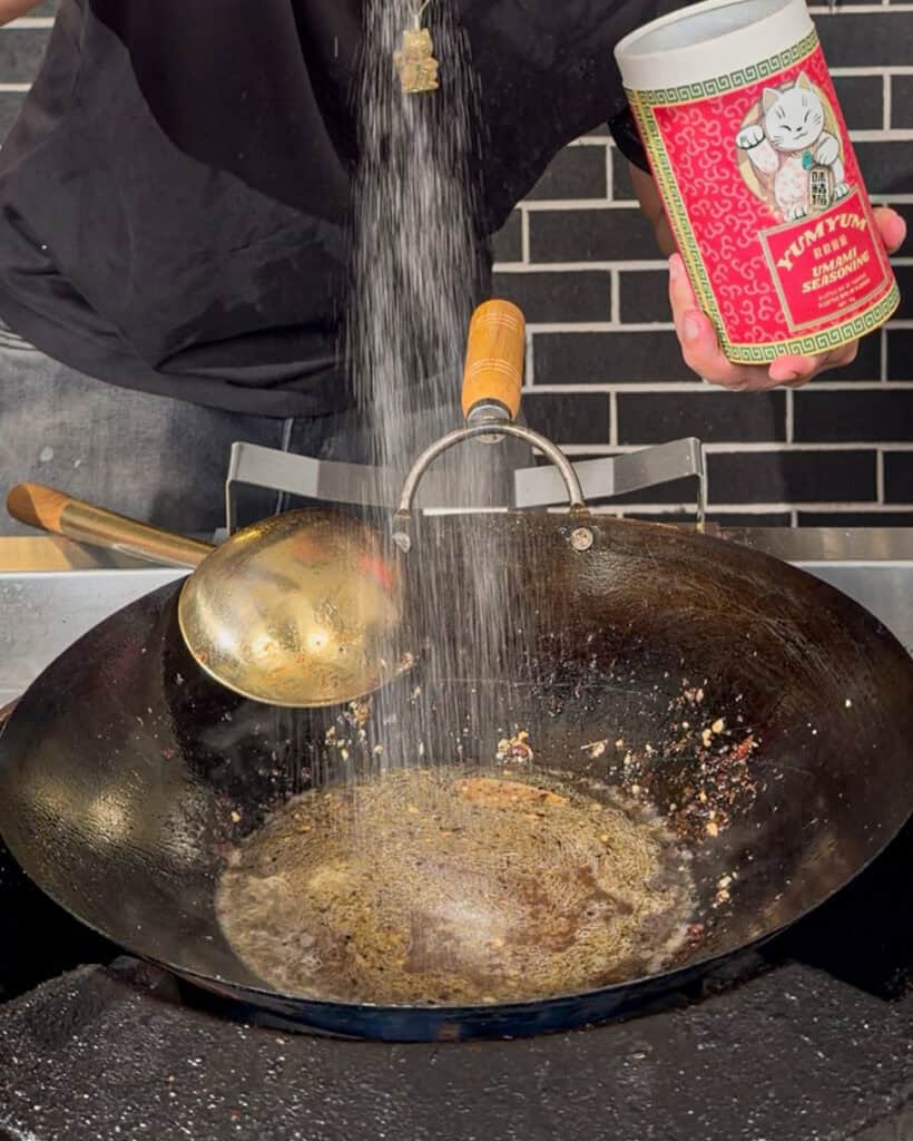 Seasoning from a large container is being poured