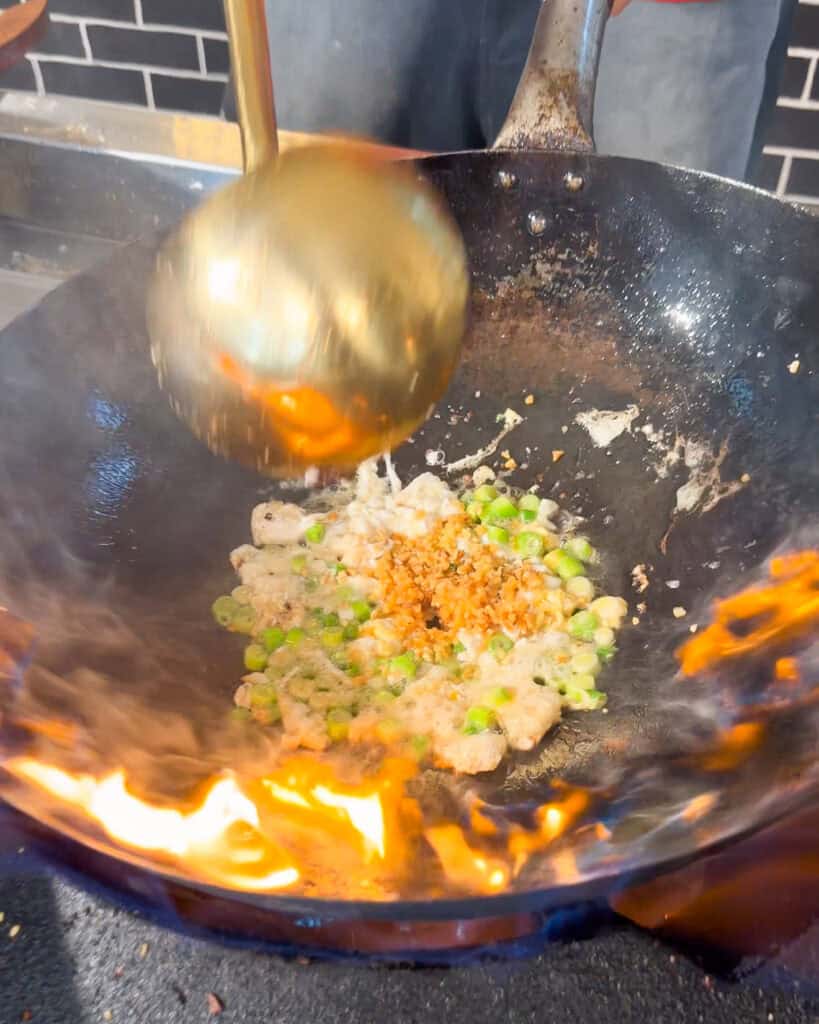 Beef and Broccoli Fried Rice egg with chopped green pieces and minced golden bits in a wok