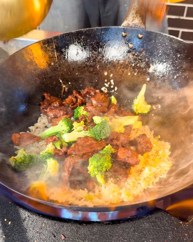 Beef and Broccoli Fried Rice rice visible in a wok with beef and broccoli