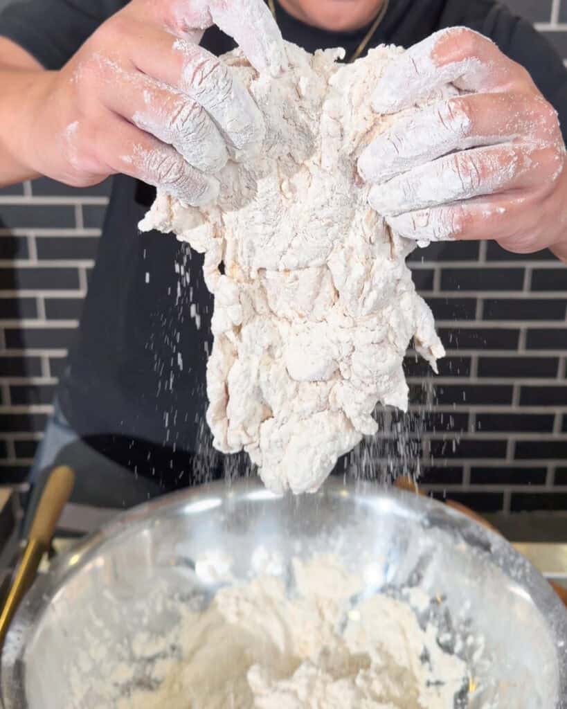 Chicken fully coated in dry flour batter before frying for crispy chicken chop.