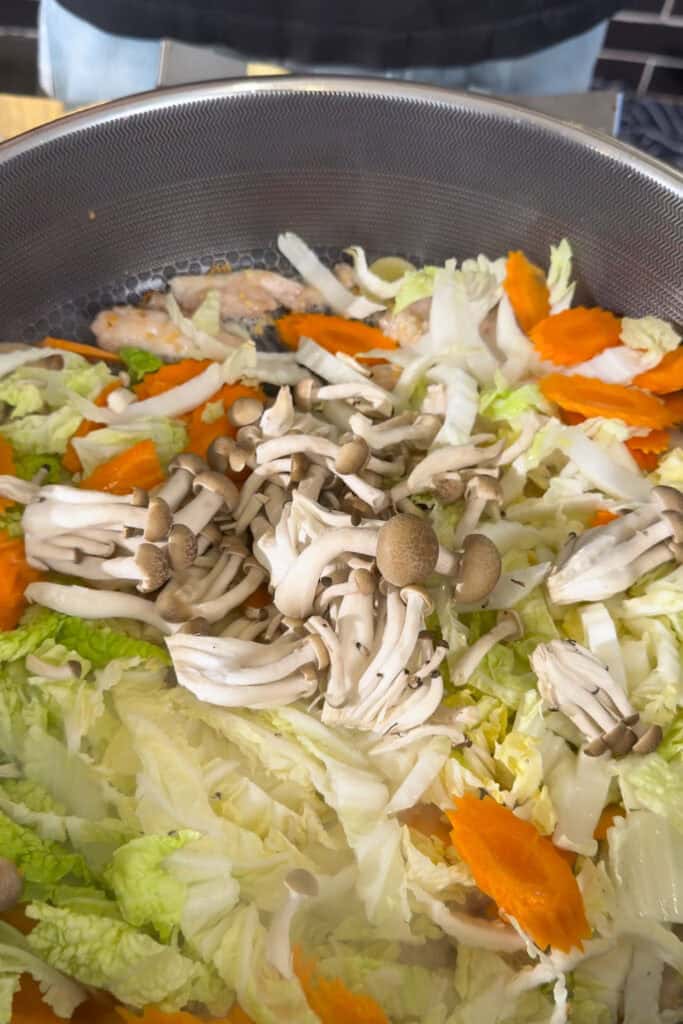 Oyster mushrooms added over wombok cabbage and carrots