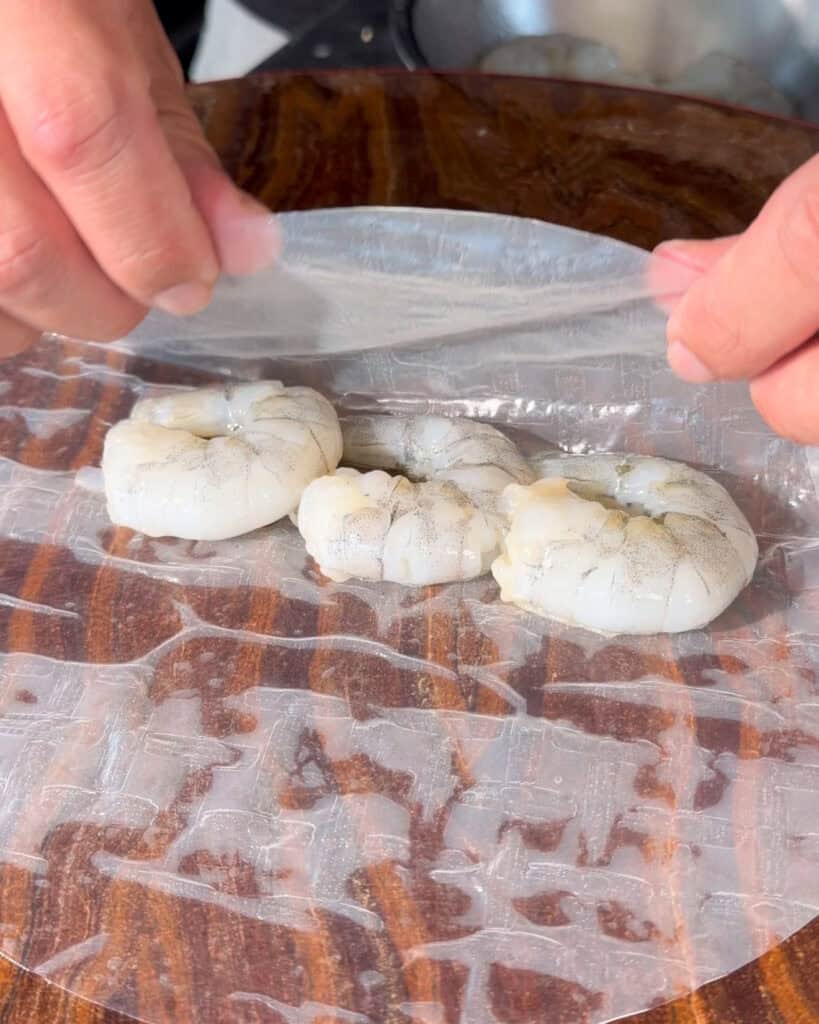 Raw prawns placed on softened rice paper