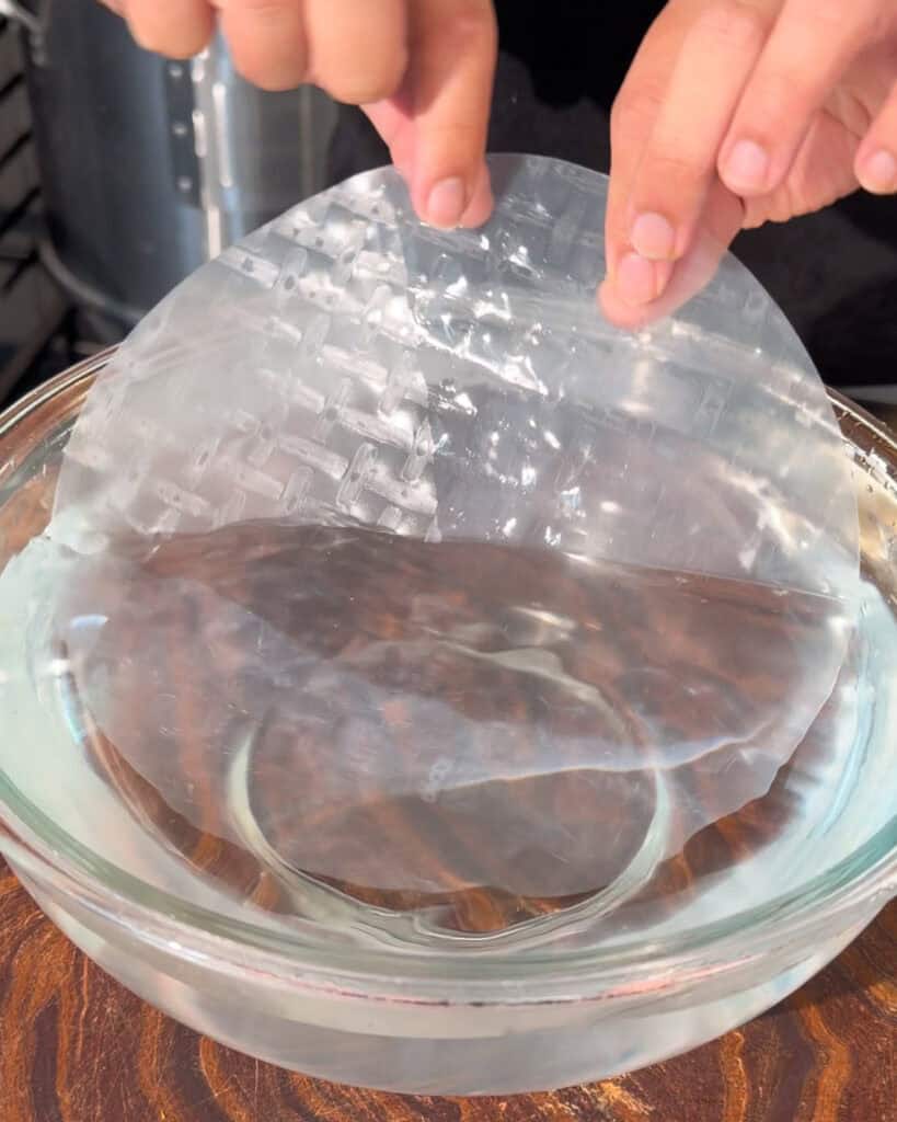 Rice paper sheet being dipped in water