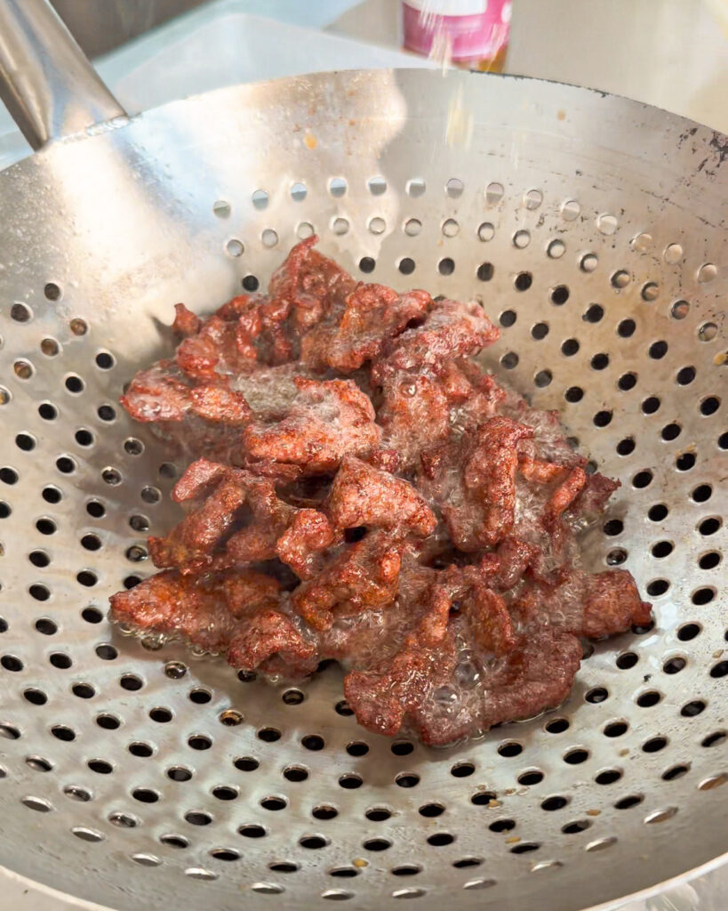 Beef pieces frying in hot oil