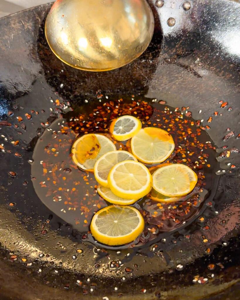 Lemon slices with chilli flakes and oil in a wok